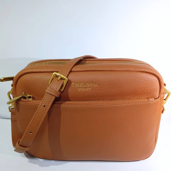 Brown leather bag with gold accents on a white background