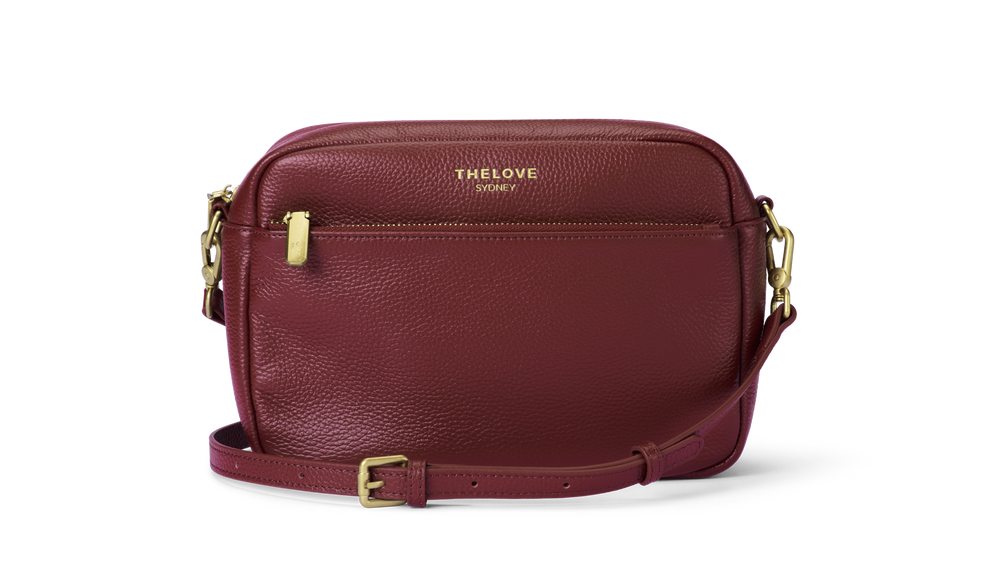 Mel Roomy Leather crossbody bag in Red Berry with gold accents.