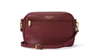 Mel Roomy Leather crossbody bag in Red Berry with gold accents.